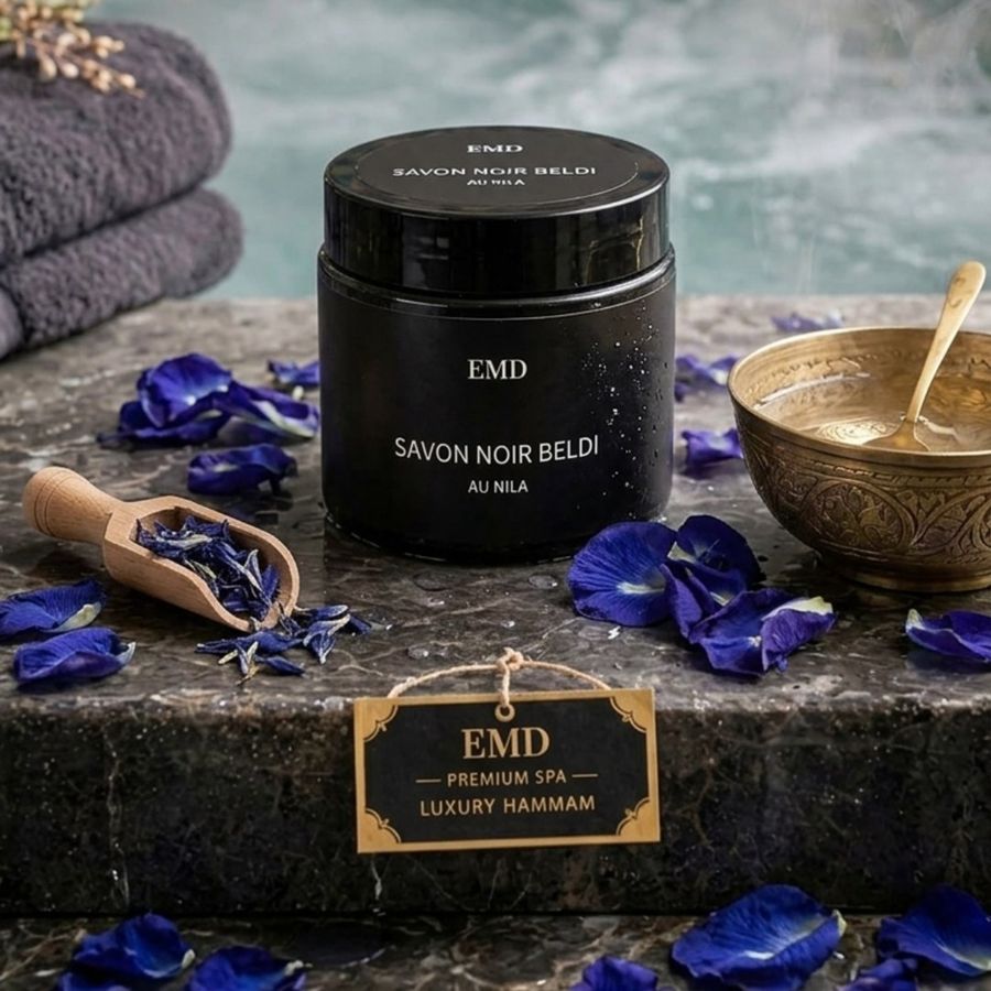 Savon noir beldi au nila entouré de pétales bleus, dans un hammam